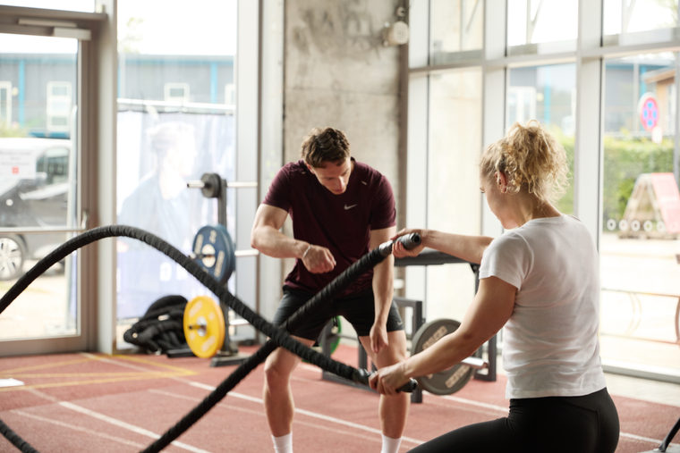 Udøver træner med battle ropes